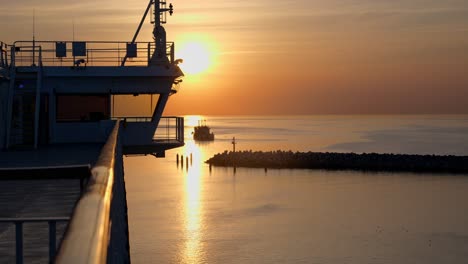 Die-Fähre-Fährt-Durch-Das-Hafentor,-Man-Kann-Das-Ruhige-Meer-Durch-Die-Kapitänsbrücke-Und-Einen-Wunderschönen-Sonnenuntergang-An-Einem-Ruhigen-Frühlingsabend-Sehen