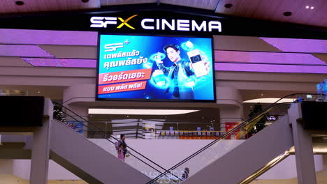 Moviegoers-going-up-and-down-a-movie-theater-inside-a-shopping-center-in-the-middle-of-Bangkok,-Thailand