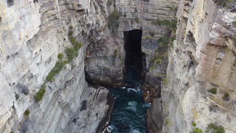 Devil's-Kitchen,-located-in-Tasmania,-is-a-mesmerizing-geological-wonder-characterized-by-dramatic-sea-cliffs,-deep-gorges,-and-tumultuous-ocean-waves