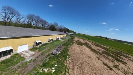 Fpv-drone-flight-over-silo-storage-on-farm-with-large-barn-house-for-animals-in-USA