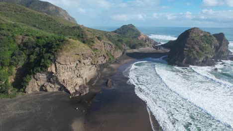 Piha-Beach-And-Taitomo-Island-In-Summer-With-Rough-Waves-In-Auckland,-New-Zealand