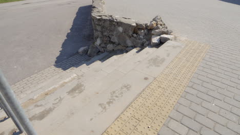 Eingestürzte-Steinmauer-In-Der-Stadt-Neben-Betonplatten,-Schlecht-Gewartete-Infrastruktur,-Mittlere-Handaufnahme