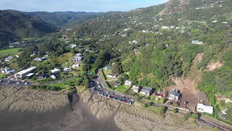 Vista-Aérea-De-La-Playa-De-Piha-Y-El-Asentamiento-Costero-En-El-Oeste-De-Auckland,-Nueva-Zelanda