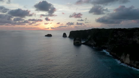 Escarpment-drop-off-cliffs-of-Nusa-Penida-Bali-with-setting-sun-below-horizon