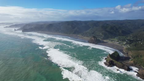 Luftaufnahme-Des-Piha-Beach-Im-Sommer-Mit-Schäumenden-Wellen-In-Auckland,-Neuseeland