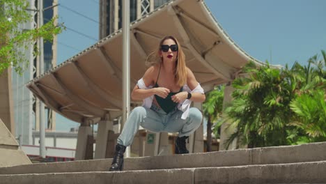 In-a-Caribbean-city,-a-young-girl-clad-in-jeans-and-boots-embarks-on-an-adventure,-with-tall-buildings-towering-behind-her