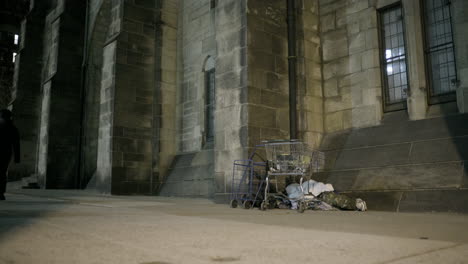 Pedestrian-Passes-Sleeping-Homeless-Person-During-Cold-Night-in-New-York-City