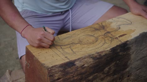 Wood-Carver-Draws-The-Pattern-Of-The-Barong-Mask-On-The-Wood-With-A-Pencil