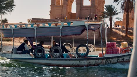 Tourist-boat-cruise-in-Nile-passing-by-the-Agilkia-Island-with-Philae-temple-complex