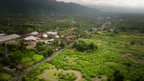 Beautiful-slow-motion-aerial,-Balinese-highway-traffic,-green-landscape