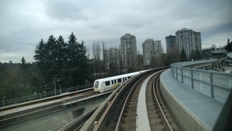 Skytrain-Sobre-Vías-De-Ferrocarril-Acercándose-A-La-Estación-En-Vancouver,-Canadá