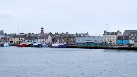 Close-up-view-of-harbour-with-moored-ships,-boats,-and-waterfront-houses-and-shops-in-Stornoway-town,-Outer-Hebrides,-Scotland-UK