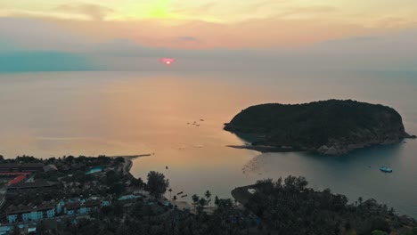 Aerial-drone-shot-of-a-sunset-over-coastal-island-and-village-in-Thailand