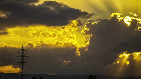 Time-lapse-of-dramatic-sunset-clouds-moving-over-power-wires-and-mountains