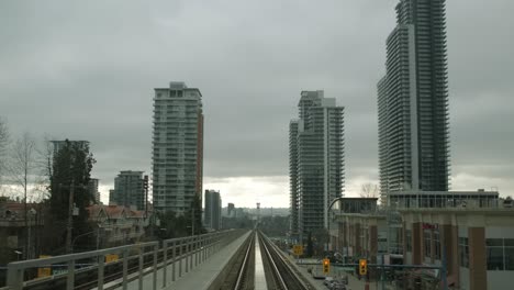 Viajando-En-Ferrocarril-Elevado-En-La-Ciudad-Con-Edificios-Altos-En-Vancouver,-Columbia-Británica,-Canadá