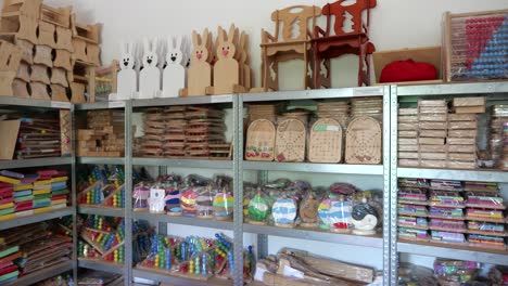 Wooden-games-wrapped,-stored-on-shelf-in-small-game-factory,-ready-for-shipping