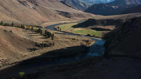 Drohnenaufnahmen-Von-Der-Landung-Eines-Einmotorigen-Flugzeugs-Auf-Einer-Abgelegenen-Landebahn,-Umgeben-Von-Bergen-Und-Einem-Fluss-In-Der-Wildnis-Des-Frank-Church-River-Of-No-Return-In-Idaho