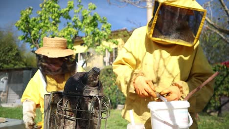 Ein-älteres-Imkerpaar-Mit-Bienenraucher-Und-Oxalsäurespritze-Im-Bienenstock