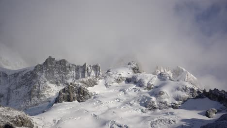 Snow-covered-peaks-of-the-Guillaumet-under-drifting-clouds,-time-lapse-shot-of-majestic-mountain-scenery