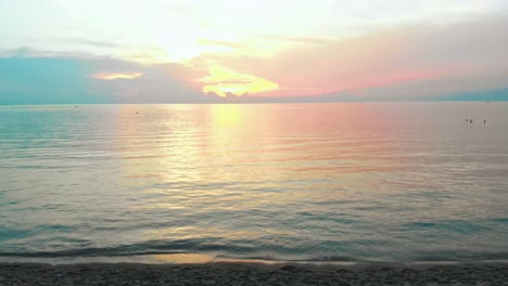 Drohne-Fliegt-Bei-Sonnenuntergang-In-Thailand-Am-Strand-Durch-Ein-Zelt-In-Richtung-Meer