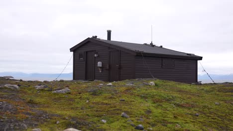 Wooden-Hut-on-Hilltop-in-Landscape-of-Island-in-Svalbard-Archipelago,-Norway