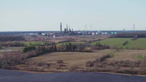 Wide-aerial-shot-of-expansive-industrial-complex-with-solar-panels-and-wind-turbines-in-rural-setting