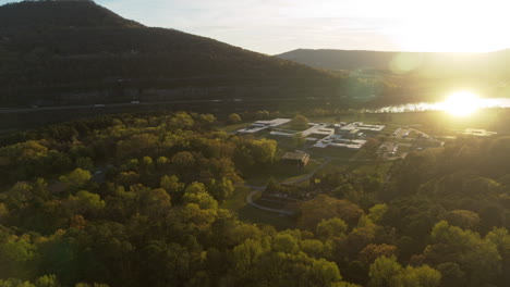 Aerial-footage-flying-away-from-Moccasin-Bend-during-the-sunset-in-Chattanooga,-TN-with-the-sun-reflecting-off-of-the-Tennessee-River