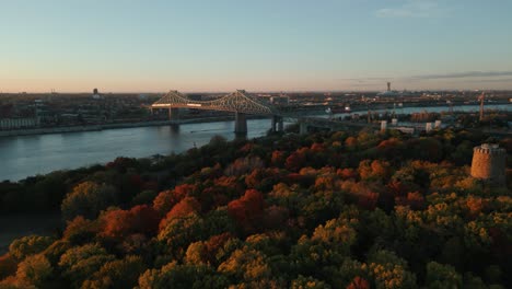 Vista-Aérea-Sobre-El-Parque-Jean-Drapeau-En-Montreal-Con-Vistas-Al-Puente-Jacques-Cartier-Y-La-Torre-Levis-Durante-La-Temporada-De-Otoño-Al-Atardecer