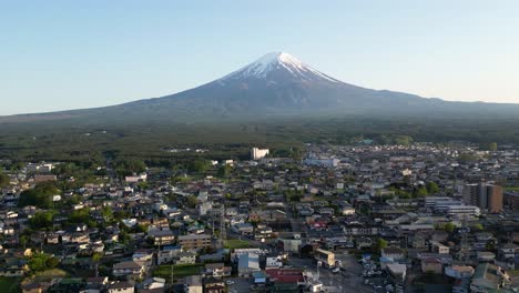 Beautiful-Mount-Fuji-with-snow-cover---Aerial-Drone-flight-over-city-in-Japan
