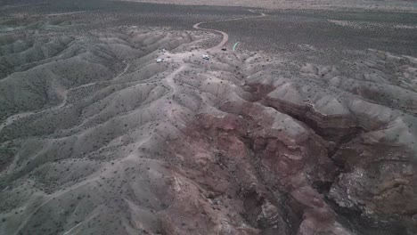 Blue-paraglider-kite-flying-over-remote-rock-formations-in-Utah-landscape