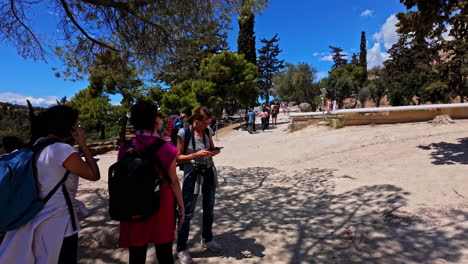 Turistas-Descansando-Antes-De-Caminar-Hasta-La-Acrópolis-De-Atenas-En-Un-Día-Caluroso,-Vista-En-Cámara-Lenta