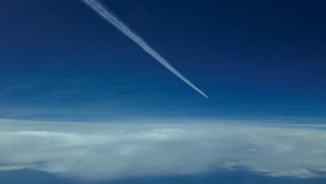 POV-Flugzeug-Wake-Fliegen-Sehr-Hoch-In-Einem-Bewölkten-Himmel-Mit-Einem-Tiefblauen-Himmel