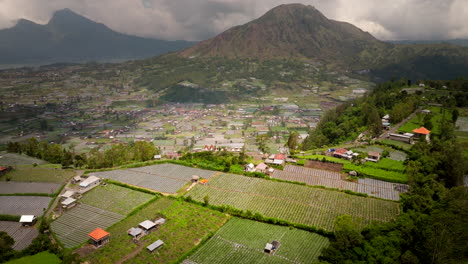 Volcano-background,-farmland-buildings,-beautiful-Indonesia,-aerial