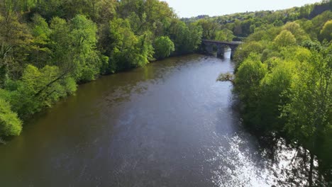Drone-flying-over-Vienne-river-in-Limoges-countryside,-Nouvelle-Aquitaine-in-France