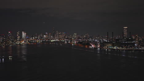 NYC-New-York-Aerial-v177-drone-flyover-East-river,-panning-views-capturing-illuminated-skyscrapers-cityscape-of-Lower-Manhattan-and-Brooklyn-at-night---Shot-with-Inspire-3-8k---September-2023