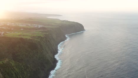 Drone-footage-of-lush-green-volcanic-island-countryside-and-ocean-bluffs-at-sunset-on-the-Azores-Sao-Miguel-Island