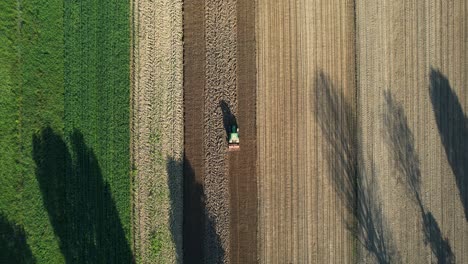 Aerial-View-of-Farmer-Tractor-with-Seedbed-Cultivator-on-Agricultural-Farmland-Parcels-for-Cultivation,-Spring-Seeding