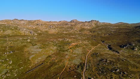 Thredbo-mountain-ski-field-during-dry-summer-season-showing-grass-and-rocks,-NSW,-Australia