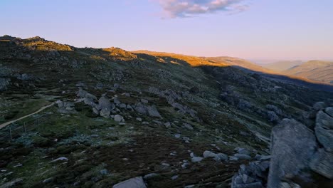 Aerial-reveal-of-Snowy-Mountains-vista-in-summer-from-behind-rocky-outcrop,-New-South-Wales,-Australia