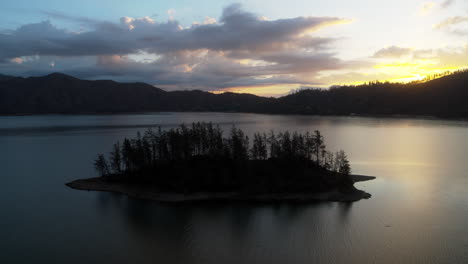 Slow-aerial-dolly-over-a-silhouetted-island-on-Whiskeytown-Lake-during-the-sunrise-in-Northern-California