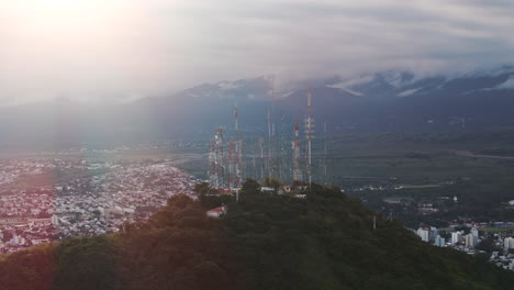 Aerial-Track-Shot-Of-Mountain-Top-Antennas-With-Salta,-Capital-City-Of-Argentina-Beyond
