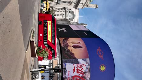 Red-Double-Decker-Bus-Passing-Through-Piccadilly-Circus-in-London-On-Sunny-Morning