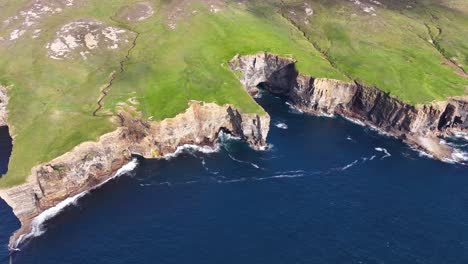 Aerial-View-of-Steep-Cliffs-Above-Sea-and-Green-Pastures-on-Coastline-of-Scotland-UK