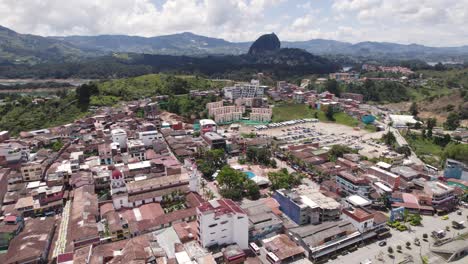 Dense-populated-town-of-Guatape-Colombia-with-hotel-and-churches,-aerial