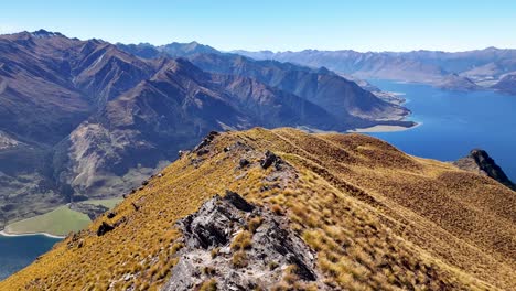 Mountain-range-and-Lake-Hawea-drone-flyover-Isthmus-Peak-rocks,-beautiful-New-Zealand-landscape