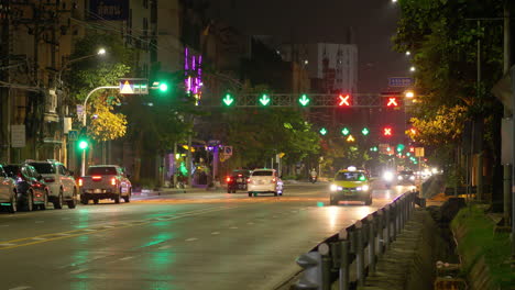 Abendliche-Straßenaufnahme-Von-Autos,-Die-Nachts-Unterwegs-Sind,-Mit-Grünen-Pfeilen-Und-Roten-Lichtern