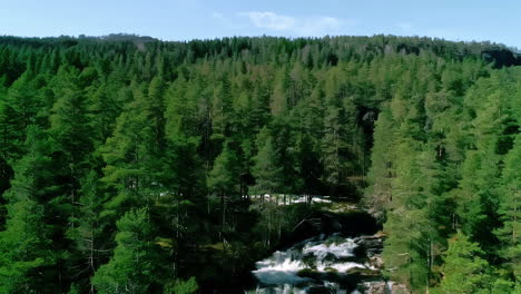 Aerial-View-of-River-Cascades-in-the-Middle-of-Evergreen-Forest-in-Countryside-of-Norway-on-Sunny-Day,-Drone-Shot