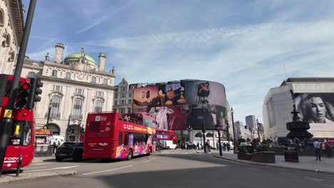 On-a-sunny-morning,-Sightseeing-Tourist-Bus-Passing-Through-Piccadilly-Circus-in-London