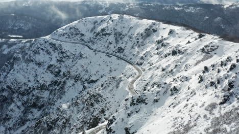 Ein-Schneebedeckter-Berg-Mit-Kurvenreichen-Straßen,-Aufgenommen-Bei-Tageslicht,-Luftaufnahme