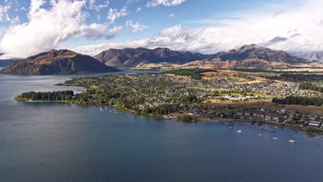 Stunning-cloudscape-of-Wanaka-settlement-on-big-lake-surrounded-by-mountains